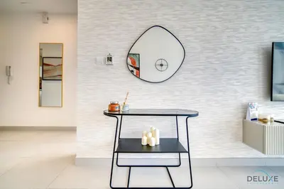 a room with a table and a mirror on the wall at Deal of the Week Stylish 1BR with Partial Burj Views by Deluxe Holiday Homes in Dubai