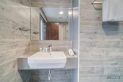a bathroom with a white sink and a mirror at Deal of the Week Stylish 1BR with Partial Burj Views by Deluxe Holiday Homes in Dubai