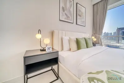 a bedroom with a bed and a desk with a window at Deal of the Week Stylish 1BR with Partial Burj Views by Deluxe Holiday Homes in Dubai