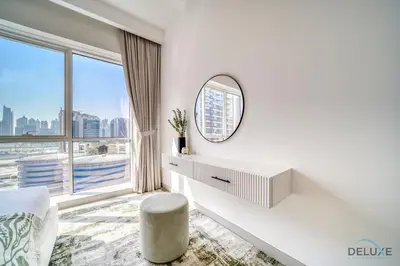 a white bedroom with a mirror and a window at Deal of the Week Stylish 1BR with Partial Burj Views by Deluxe Holiday Homes in Dubai
