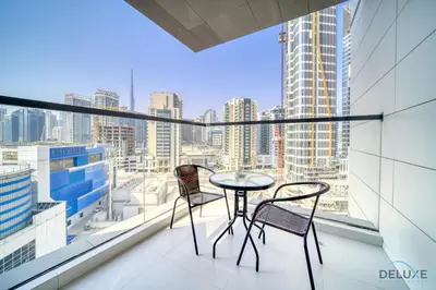 a table and two chairs on a balcony with a view at Deal of the Week Stylish 1BR with Partial Burj Views by Deluxe Holiday Homes in Dubai