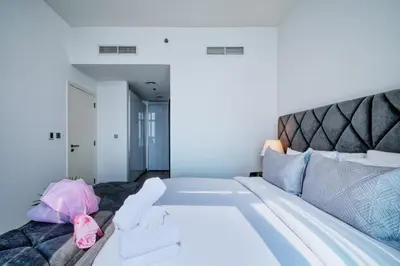 a bedroom with a large bed with a pink bag on it at GlobalStay Royal Bay Beachfront Apartments Palm Jumeirah in Dubai