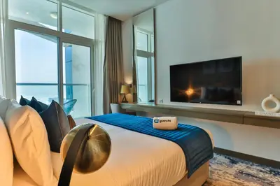 a bedroom with a large bed with a tv on the wall at HiGuests - Roomy and Chic Studio with Panoramic Canal Views in Dubai