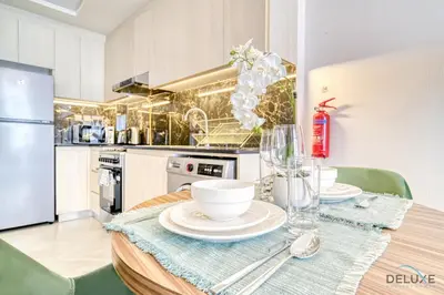 a kitchen with a table with plates and glasses on it at Prime 1BR at Binghatti Avenue Al Jaddaf by Deluxe Holiday Homes in Dubai