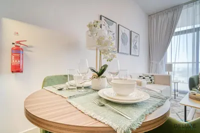 a dining room table with plates and wine glasses at Prime 1BR at Binghatti Avenue Al Jaddaf by Deluxe Holiday Homes in Dubai