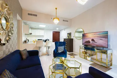 a living room with blue furniture and a large screen tv at Dubai Marina Royal Premium Serviced Apartments Marina Wharf - KIDS STAY FREE plus free check in 24 hours in Dubai