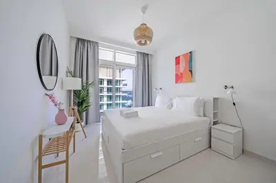 a white bedroom with a bed and a mirror at Breathtaking Atlantis view, Spacious 2BR on beach in Dubai