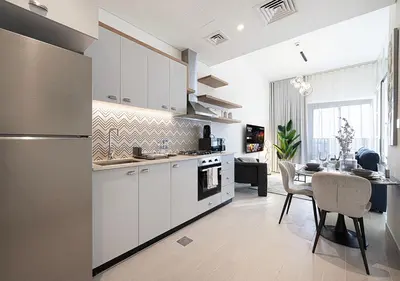 a kitchen with white cabinets and a table and a dining room at First Class Apartments in Dubai Hills - Next to Dubai Hills Mall - Socio, Collective and Golfville Towers in Dubai