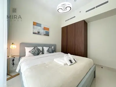 a bedroom with a large white bed with a wooden headboard at Mira Holiday Homes - Newly furnished 1 bedroom in Business Bay in Dubai