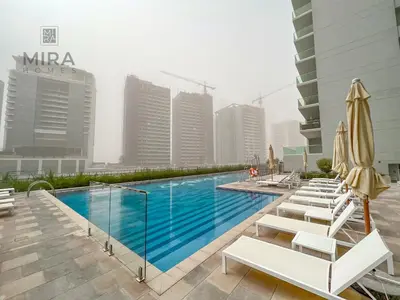 a swimming pool with chairs and umbrellas on a building at Mira Holiday Homes - Newly furnished 1 bedroom in Business Bay in Dubai