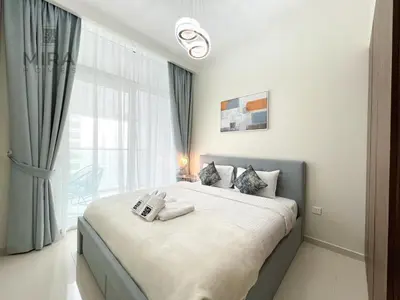 a bedroom with a large bed with a large window at Mira Holiday Homes - Newly furnished 1 bedroom in Business Bay in Dubai