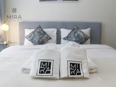 a bed with white towels and pillows on it at Mira Holiday Homes - Newly furnished 1 bedroom in Business Bay in Dubai