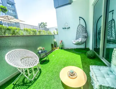 a small backyard with grass and a table and chairs at STAY BY LATINEM Luxury 1BR Holiday Home CV A107 near Burj Khalifa in Dubai
