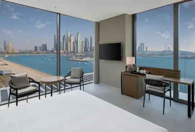 a bedroom with a bed and a desk and chairs at Radisson Beach Resort Palm Jumeirah in Dubai