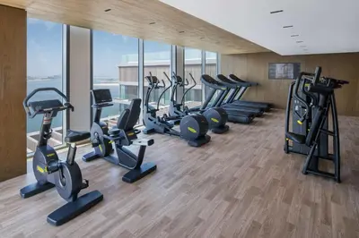 a gym with a row of treadms and cardio machines at Radisson Beach Resort Palm Jumeirah in Dubai