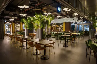 a restaurant with tables and chairs and plants at Radisson Beach Resort Palm Jumeirah in Dubai
