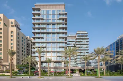 a tall building with palm trees in front of it at Radisson Beach Resort Palm Jumeirah in Dubai