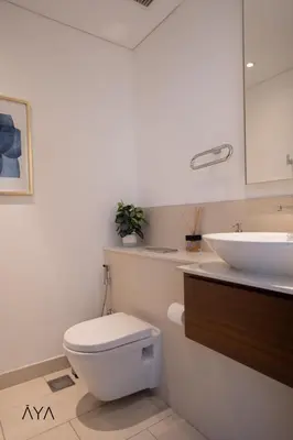 a bathroom with a white toilet and a sink at Luxury Apartment with Pool, Patio & Gym in City Walk By ĀYA Boutique in Dubai
