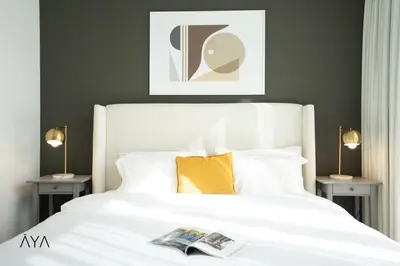 a bedroom with a white bed with two side tables at Luxury Apartment with Pool, Patio & Gym in City Walk By ĀYA Boutique in Dubai