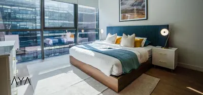 a bedroom with a large bed and a large window at Luxury Apartment with Pool, Patio & Gym in City Walk By ĀYA Boutique in Dubai