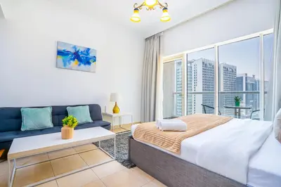 a bedroom with a bed and a couch at RH- Chic & Sleek Studio apartment, near Burj Khalifa in Dubai
