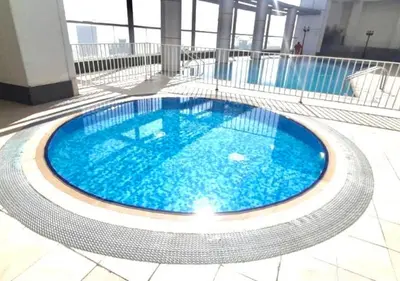 a large swimming pool with blue water in a building at RH- Contemporary Studio, Downtown, Near Dubai Mall & Burj Khalifa in Dubai