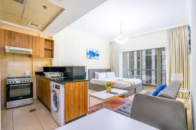 a living room with a kitchen and a couch at RH- Contemporary Studio, Downtown, Near Dubai Mall & Burj Khalifa in Dubai