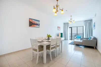 a dining room and living room with a table and chairs at RH- Modern Elegance 2BR, prime location, Walk to Dubai Mall in Dubai