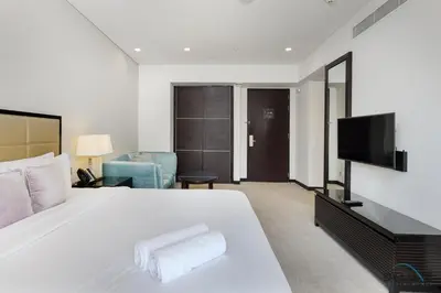 a bedroom with a large white bed and a television at Marina Canal Views Next to Mall & Marina Promenade Studio Unit, The Address Residences, Dubai Marina by Deluxe Holiday Homes in Dubai