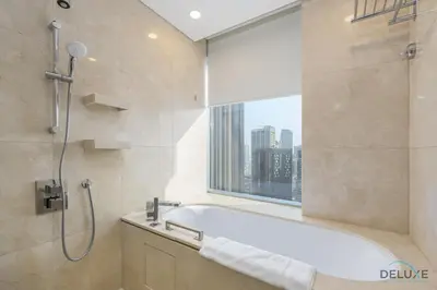a bathroom with a bath tub and a window at Marina Canal Views Next to Mall & Marina Promenade Studio Unit, The Address Residences, Dubai Marina by Deluxe Holiday Homes in Dubai