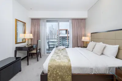 a hotel room with a bed and a desk and a window at Marina Canal Views from the Balcony, Close to Marina Mall, The Address Residences, Dubai Marina by Deluxe Holiday Homes in Dubai