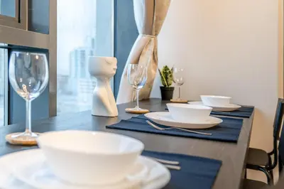 a table with white plates and wine glasses on it at GuestReady - Zen in the heart of JVC in Dubai