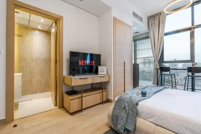 a bedroom with a bed and a flat screen tv at GuestReady - Zen in the heart of JVC in Dubai