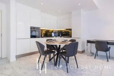 a dining room with a table and chairs and a kitchen at LUX The Pad Executive Suite Canal View 4 in Dubai