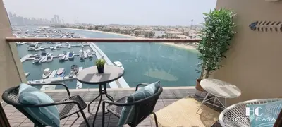 a balcony with a view of a harbor with boats at Palm Jumeirah Upgraded & Cozy Boutique Apartment in Dubai