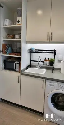 a white kitchen with a sink and a stove at Palm Jumeirah Upgraded & Cozy Boutique Apartment in Dubai