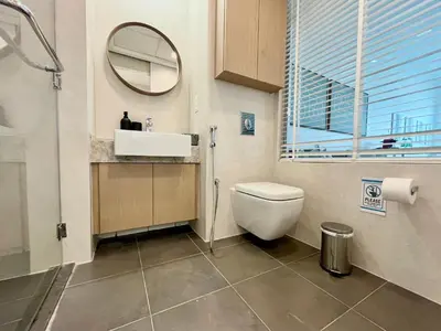 a bathroom with a toilet and a sink and a mirror at Palm Jumeirah Upgraded & Cozy Boutique Apartment in Dubai