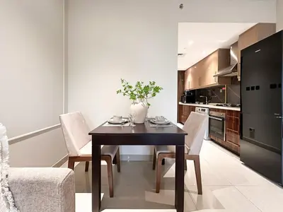 a dining room with a table and chairs in a kitchen at Trophy - Downtown Scape Views Suite in Dubai