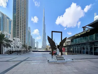 a city street with a statue of wings in a city at Trophy - Downtown Scape Views Suite in Dubai