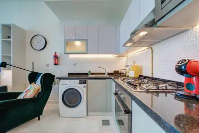 a kitchen with a washing machine and a stove at Lovely studio in Business Bay in Dubai