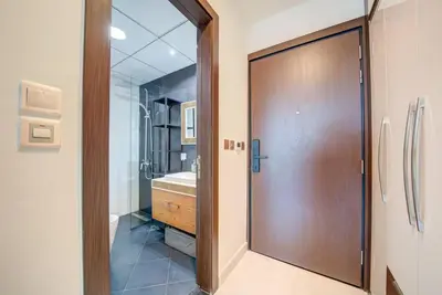 a bathroom with a wooden door and a sink at Lovely studio in Business Bay in Dubai