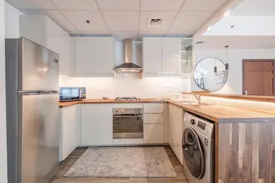 a kitchen with white cabinets and a dishwasher at 1BDR Apartment in Dubai Marina with Marina Views in Dubai