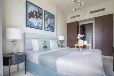 a bedroom with a bed and a table with flowers at Frank Porter - Vera Residence in Dubai