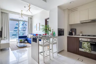 a kitchen and living room with a bar and a couch at Frank Porter - Vera Residence in Dubai
