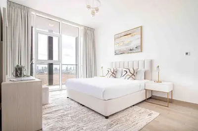 a white bedroom with a large bed and a window at Frank Porter - Bloom Tower A in Dubai