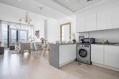 a kitchen and dining room with a table and a dishwasher at Frank Porter - Bloom Tower A in Dubai