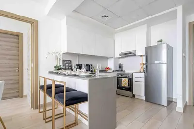a kitchen with a stainless steel refrigerator and a stove at Frank Porter - Bloom Tower A in Dubai