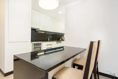 a kitchen with a black counter top and a chair at Marina Canal Views 1BR Minutes Away from Marina Mall, The Address Residences, Dubai Marina by Deluxe Holiday Homes in Dubai