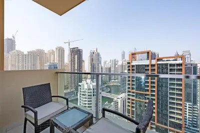 a balcony with a chair and a view of the city at Marina Canal Views 1BR Minutes Away from Marina Mall, The Address Residences, Dubai Marina by Deluxe Holiday Homes in Dubai