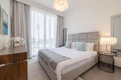 a bedroom with a large bed and a large window at Spacious 2BDR in Creek Harbor with City View in Dubai